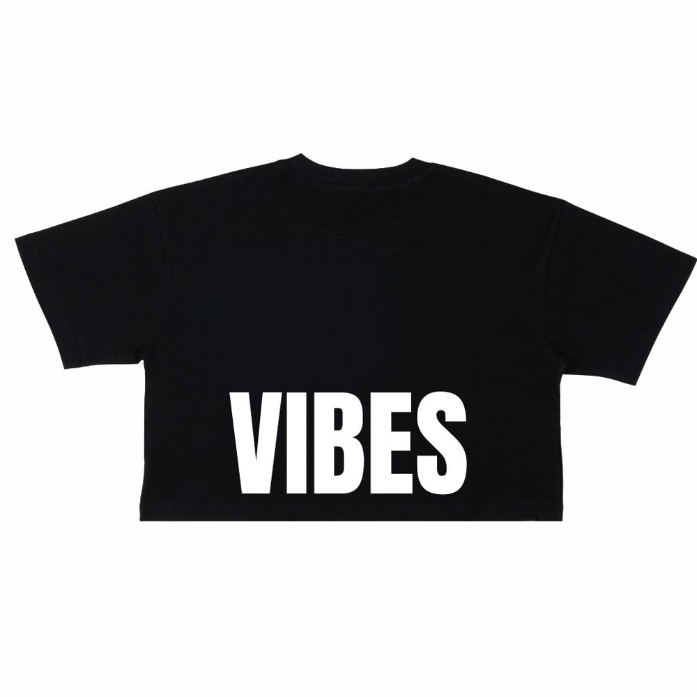 Image features the back of the Be Kind Vibes Be Kind crop top in black with the word Vibes printed in white just above the bottom seam