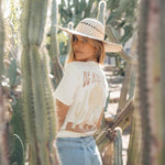 Hero image featuring the back of the Be Kind Vibes Desert Waves tee in natural