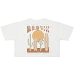 Image features the back of the Be Kind Vibes Desert Waves crop top. The design features a sun, cacti, and surfboards with the brand name Be Kind Vibes written over the top