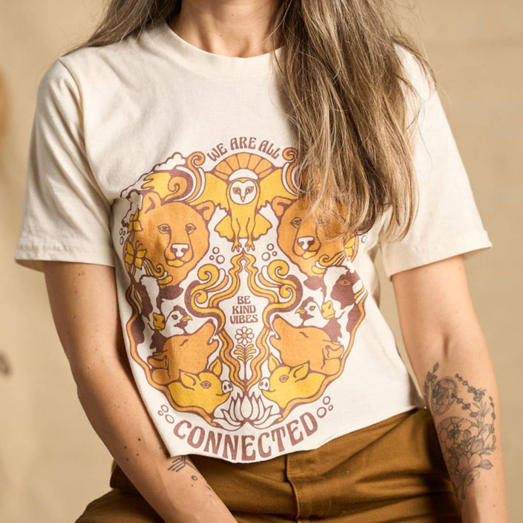 
                  
                    Hero image features a female model wearing the Be Kind Vibes We Are All Connected crop top with an animal design on the front featuring bears, cows, chickens, wolves, pigs, and an owl.
                  
                