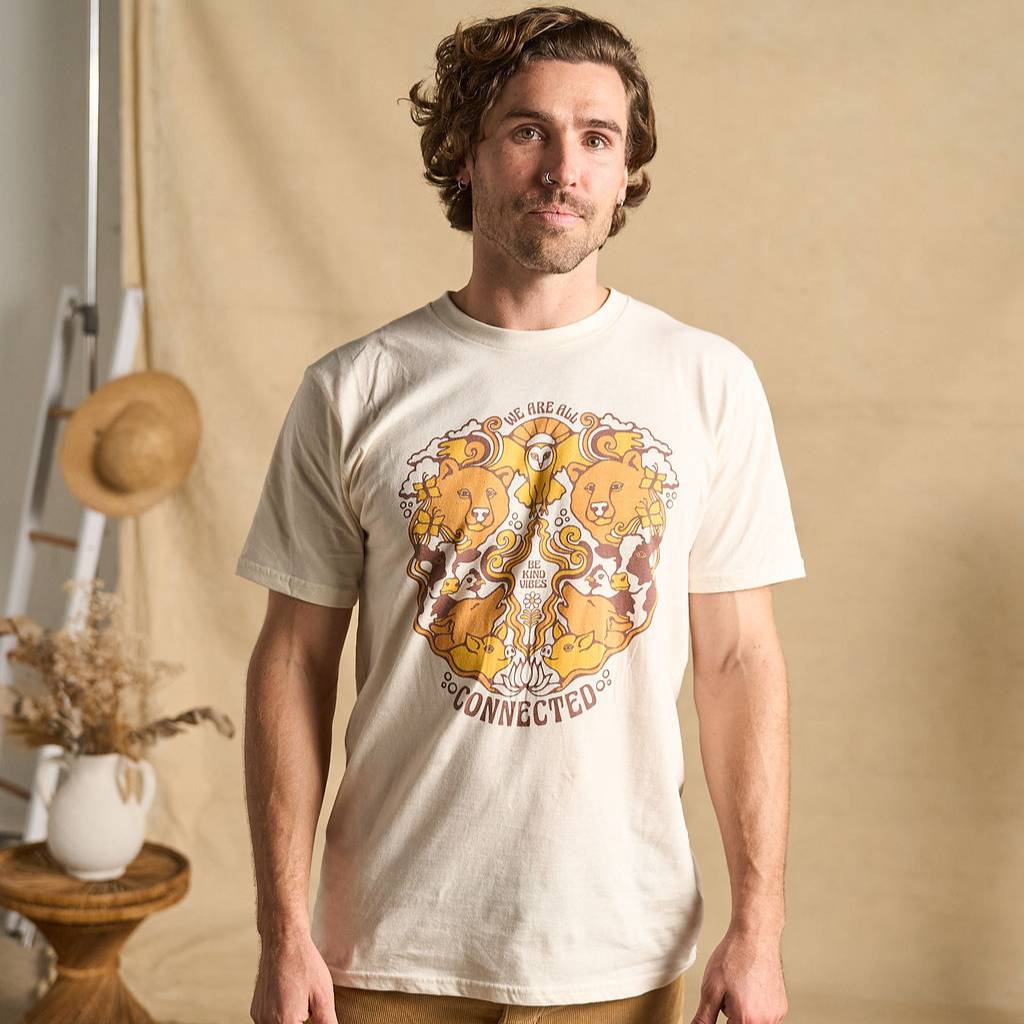 Hero image features a male model wearing the Be Kind Vibes We Are All Connected t-shirt with an animal design on the front featuring bears, cows, chickens, wolves, pigs, and an owl.