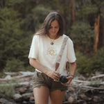 Image features a female model walking thru the woods holding a film camera wearing the sustainably made hemp & organic cotton Be Kind & Shine crop top in natural by Be Kind Vibes.