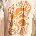 Image features the back design of the Be Kind Vibes organic cotton To the Sea t-shirt which features a whale, dolphin, ocean waves, and ocean plants with the text Be Kind to the Sea and Be Kind Vibes written throughout.